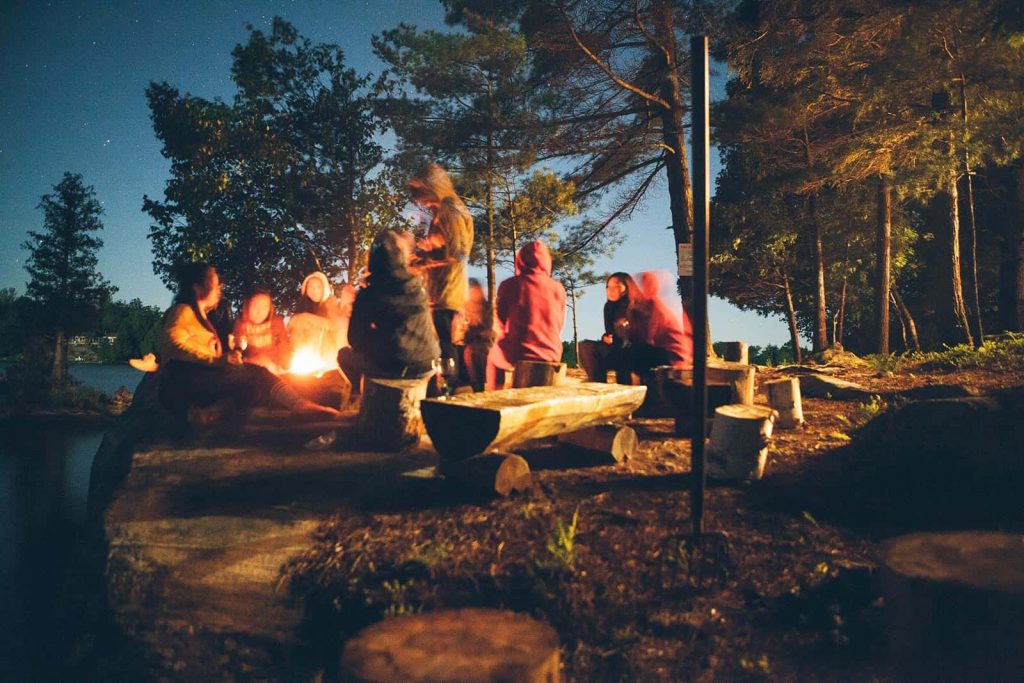 شب نشینی در کنار آتش در یک کمپ پاییزی